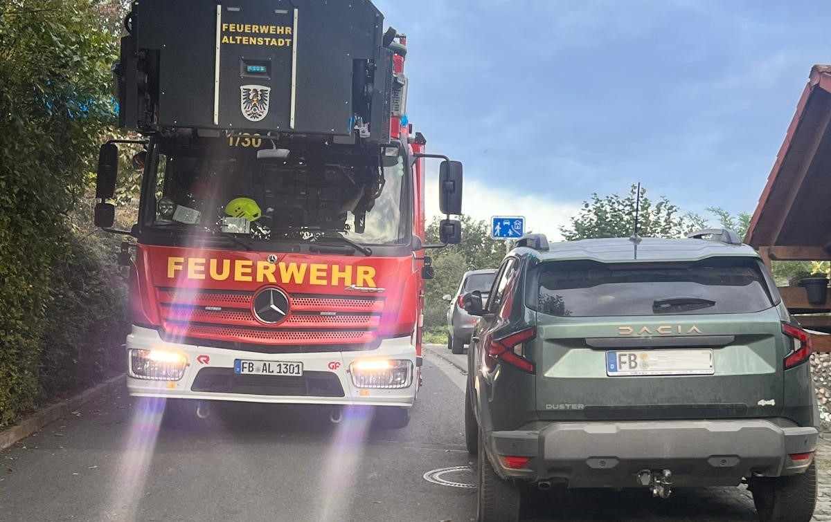 Drehleiter passiert einen abgestellten Pkw