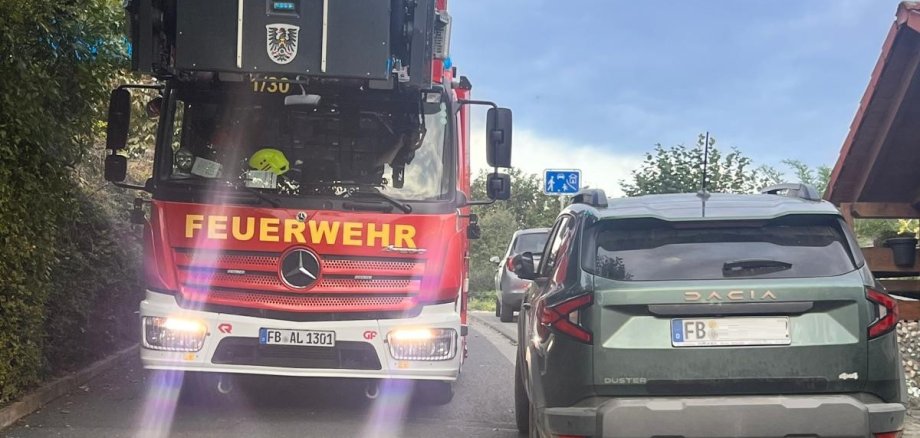 Drehleiter passiert einen abgestellten Pkw