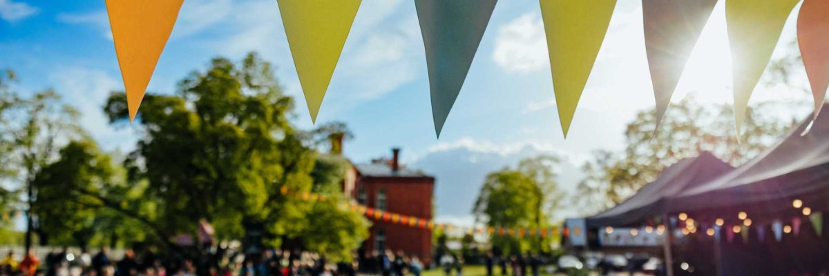 Bild eines Festplatzes (Wiese) mit bunten Wimpeln