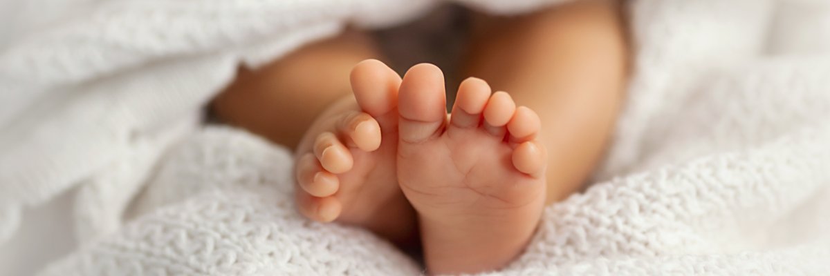 2025_Standesamt_Geburt_Babyfüsse Babyfüsse in weißer Decke gehüllt