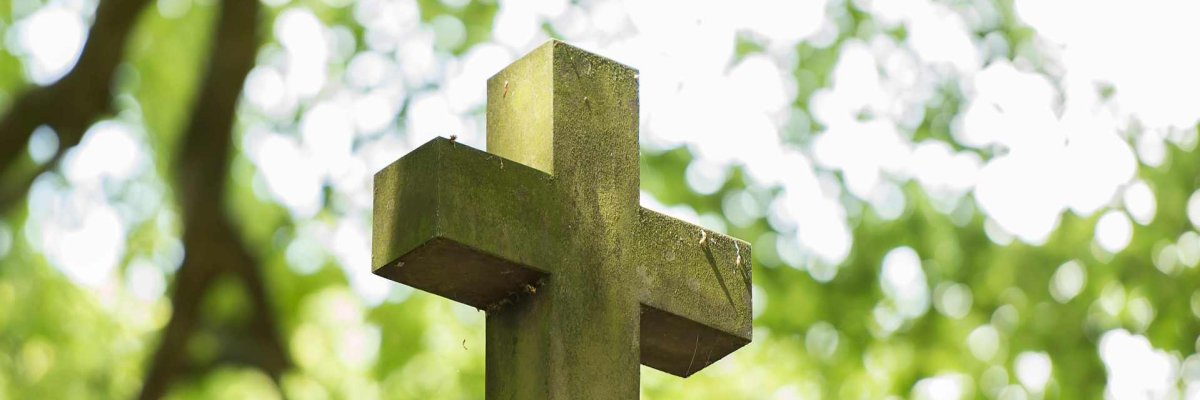 Blick auf Steinkreuz; Hintergrund Bäume
